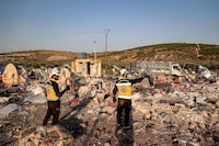 Members of the Syrian Civil Defence (White Helmets) survey the area following a Russian air strike, at a camp for those displaced by conflict on the outskirts of the rebel-held village of al-Hamamah in the district of Jisr al-Shughur in thr west of Syria's northwestern Idlib province on October 24, 2023. Six people, including two children, were killed on October 24 in Russian strikes on a displacement camp in Syria's northwest, the country's last main rebel bastion, according to the Syrian Observatory for Human Rights. Tensions have soared in the rebel-held area since a drone attack on a military academy graduation ceremony in Homs earlier this month killed dozens of people, with the government blaming "terrorists". (Photo by AAREF WATAD / AFP) (Photo by AAREF WATAD/AFP via Getty Images)