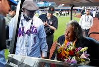 Former New York Mets Mookie Wilson, left, presents Rachel Robinson with flowers in honor of Jackie Robinson Day before a baseball game between the Mets and the Pittsburgh Pirates Monday, April 15, 2024, in New York. (AP Photo/Noah K. Murray)