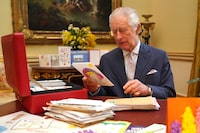 FILE PHOTO: Britain's King Charles reads cards and messages, sent by well-wishers following his cancer diagnosis, in the 18th Century Room of the Belgian Suite in Buckingham Palace, London, Britain, February 21, 2024. Jonathan Brady/Pool via REUTERS