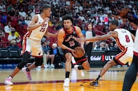Toronto Raptors forward Jordan Nwora (13) comes under pressure from Miami Heat center Orlando Robinson (25) and forward Jamal Cain (8) during the second half of an NBA basketball game, Sunday, April 14, 2024, in Miami. (AP Photo/Rebecca Blackwell)