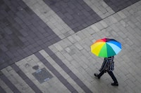 Much of British Columbia's south coast is bracing for stormy weather as Environment Canada says a "potent and impactful" storm will bring heavy rain to Metro Vancouver. A pedestrian carries an umbrella as light rain falls in Surrey, B.C., on Friday, October 21, 2022. THE CANADIAN PRESS/Darryl Dyck