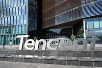 (FILES) This photo taken on July 10, 2022 shows people walking past the Tencent headquarters in Shenzhen in China's southern Guangdong province. Chinese internet giant Tencent on March 20, 2024 posted its lowest annual profit since 2019, despite slight improvements recently in China's economy and a more lenient attitude taken by regulators towards the tech sector. (Photo by Jade GAO / AFP) (Photo by JADE GAO/AFP via Getty Images)