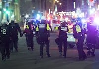 Police patrol Ste-Catherine Street in Montreal, Monday, April 12, 2021, during an 8 p.m. curfew imposed by the Quebec government to help curb the spread of COVID-19, as the COVID-19 pandemic continues in Canada and around the world. THE CANADIAN PRESS/Graham Hughes