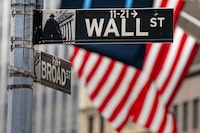 Street signs at the center of the New York City financial district frame the U.S. Flags flying from the front of the New York Stock Exchange, Wednesday, Aug. 16.