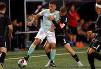 Pacific FC's Manny Aparicio, left, protects the ball from TSS Rovers' Matteo Polisi during second half Canadian Championship quarterfinal soccer action in Langford, B.C., on Wednesday, May 10, 2023. THE CANADIAN PRESS/Chad Hipolito