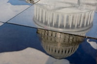 The U.S. Capitol is reflected in a dwindling puddle in the midst of ongoing negotiations seeking a deal to raise the United States' debt ceiling and avoid a catastrophic default, in Washington, U.S. May 24, 2023.  REUTERS/Jonathan Ernst