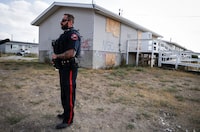 Blood Tribe Police Service Const. Manasse Gabor stands outside of a boarded up house in Standoff, Alta., on Friday, Aug. 25, 2023.THE CANADIAN PRESS/Jeff McIntosh