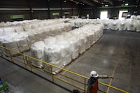 A worker walks next to bags of lithium ready for export at the SQM processing plant in Antofagasta, Chile, Wednesday, April 19, 2023. (AP Photo/Rodrigo Abd)