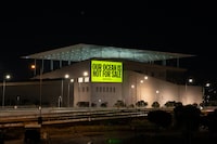 This handout photograph taken by Greenpeace Greece on April 14, 2024 shows a message reading 'Our Ocean Is Not For Sale' projected by Greenpeace Greece activists onto the SNFCC conference centre in Kallithea, near Athens. Greenpeace Greece activists project a series of ocean protection messages onto the Acropolis Hill and other sites around Athens to call for the protection of the oceans from corporate greed, ensuring justice for coastal communities, stopping deep sea mining and ratifying the UN High Seas Treaty. (Photo by Handout / GREENPEACE GREECE / AFP) / RESTRICTED TO EDITORIAL USE - MANDATORY CREDIT "AFP PHOTO /  HO / GREENPEACE GREECE" - NO MARKETING NO ADVERTISING CAMPAIGNS - DISTRIBUTED AS A SERVICE TO CLIENTS - NO ARCHIVE (Photo by HANDOUT/GREENPEACE GREECE/AFP via Getty Images)