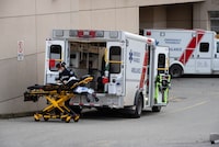 A B.C. Ambulance Service paramedic moves a stretcher outside an ambulance at Royal Columbia Hospital, in New Westminster, B.C., on Sunday, Nov. 29, 2020. A third child has died in British Columbia due to complications linked to influenza, cases of which continue to rise in the province. THE CANADIAN PRESS/Darryl Dyck