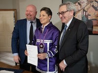 Mohawk Grand Chief Kahsennenhawe Sky-Deer, is flanked by Hydro-Québec chief executive Michael Sabia, right, and Quebec Minister of First Nations Relations Ian Lafrenière, left, after signing of the joint ownership agreement for the Hertel-New York Transmission Line, Thursday, April 18, 2024, in Kahnawake, Que.THE CANADIAN PRESS/Ryan Remiorz