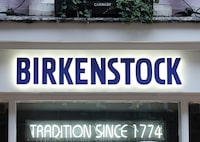 A sign is illuminated at the entrance to a Birkenstock shoe store in London, Britain, October 11, 2023. REUTERS/Toby Melville/ File Photo