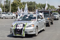 KABUL, AFGHANISTAN - AUGUST 15: A car draped with a picture of Mullah Omar, the Afghan cleric who founded the Taliban in 1994, parades with Taliban supporters on August 15, 2023 in Kabul, Afghanistan. Two years ago, the Taliban completed their return to power in Afghanistan after the fall of the Western-backed government and rapid evacuations of foreign militaries, organizations and many Afghans who worked with them. In the time since, no country has formally recognized Taliban rule. (Photo by Nava Jamshidi/Getty Images)