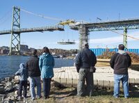 People watch as workers place a new section of the deck for the Angus L. Macdonald Bridge spanning the harbour in Halifax on Saturday, Oct. 31, 2015. Authorities are attempting to reassure Canadians about the safety of their bridges following the collapse of a bridge in Baltimore, Md., early Tuesday morning. THE CANADIAN PRESS/Andrew Vaughan