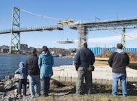 People watch as workers place a new section of the deck for the Angus L. Macdonald Bridge spanning the harbour in Halifax on Saturday, Oct. 31, 2015. Authorities are attempting to reassure Canadians about the safety of their bridges following the collapse of a bridge in Baltimore, Md., early Tuesday morning. THE CANADIAN PRESS/Andrew Vaughan