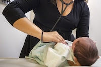 A pediatrician examines a newborn baby in her clinic in Chicago on Tuesday, Aug. 13, 2019. The Health Standards Organization released a new set of guidelines to help hospital workers manage pain in children -- particularly for those who can't communicate when they're hurt. THE CANADIAN PRESS/AP-Amr Alfiky