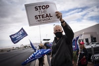 FILE - Supporters of President Donald Trump hold signs as they stand outside of the Clark County Elections Department in North Las Vegas, Nov. 7, 2020. Nevada's most populous county has disclosed correspondence to the U.S. Justice Department special counsel showing lawyers for former President Donald Trump raising concerns about the integrity of the 2020 voting process that were later deemed baseless, according to documents obtained by The Associated Press. (AP Photo/Wong Maye-E, File)