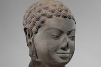 This December 2005 photo shows a 7th century sculpture titled "Head of Buddha" at the Metropolitan Museum of Art in New York. The sculpture is one of 16 pieces of artwork that the museum said it will return to Cambodia and Thailand that federal prosecutors say were tied to an art dealer and collector accused of running a huge antiquities trafficking network out of Southeast Asia. (Metropolitan Museum of Art via AP)