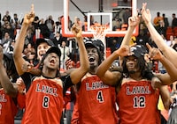 Laval University Rouge et Or players Jayden Larosiliere, from left to right, Ousmane Diawara and Willem Mwanza celebrate their victory against  Queens University at the USports men championship basketball final in Quebec City, Sunday, March 10, 2024. THE CANADIAN PRESS/Jacques Boissinot