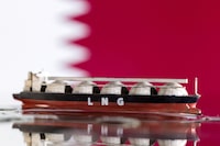 FILE PHOTO: Model of LNG tanker is seen in front of Qatar's flag in this illustration taken May 19, 2022. REUTERS/Dado Ruvic/Illustration/File Photo