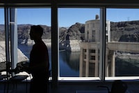 FILE - People attend a news conference on Lake Mead at Hoover Dam, April 11, 2023, near Boulder City, Nev. Arizona, California and Nevada on Monday, May 22, proposed a deal to significantly cut their water use from the drought-stricken Colorado River over the next three years. (AP Photo/John Locher, File)