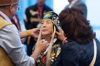 A First Nations leader from New Brunswick implored others to help stop social media attacks being launched at the Assembly of First Nations new interim chief. Newly-appointed Interim National Chief of the Assembly of First Nations Joanna Bernard, centre, gets help adjusting her regalia before leading the grand procession during the AFN annual general assembly in Halifax on Tuesday, July 11, 2023. THE CANADIAN PRESS/Darren Calabrese