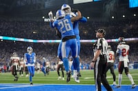 Detroit Lions running back Jahmyr Gibbs (26) celebrates his touchdown run with offensive tackle Penei Sewell during the second half of an NFL football NFC divisional playoff game against the Tampa Bay Buccaneers, Sunday, Jan. 21, 2024, in Detroit. (AP Photo/Paul Sancya)
