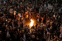 TEL AVIV, ISRAEL - MARCH 30: Protesters hold flame torches and set a fire as they are taking part in a demonstration calling for the release of hostages held in the Gaza Strip, and against Israeli prime Minister Benjamin Netanyahu and his government on March 30, 2024 in Tel Aviv, Israel. Israelis' frustrations with the government led by Benjamin Netanyahu have persisted as over 100 hostages remain captive in Gaza, after nearly six months of war between Israel and Hamas, the Palestinian militant group that attacked Israel on Oct. 7. (Photo by Amir Levy/Getty Images)