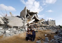 Palestinian children sit next to the site of an Israeli strike on a house, amid the ongoing conflict between Israel and the Palestinian Islamist group Hamas, in Rafah, in the southern Gaza Strip, April 21, 2024. REUTERS/Mohammed Salem