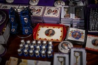 Souvenir items with the image of King Charles III and the late Queen Elizabeth II are displayed for sale at a stand in London, Wednesday, May 3, 2023. The Coronation of King Charles III will take place at Westminster Abbey on May 6. (AP Photo/Emilio Morenatti)