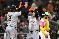 San Francisco Giants' Matt Chapman, center, is congratulated by Jorge Soler (2) after he hit a two-run home run as San Diego Padres catcher Luis Campusano (12) looks on during the ninth inning of a baseball game, Friday, March 29, 2024, in San Diego. (AP Photo/Denis Poroy)