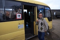 This photograph taken on October 1, 2023 during an Azeri government organized media trip shows Armenians, who are fleeing Nagorno-Karabakh, boarding a bus for Armenia in the village of Lissagorsk in the territories of the breakaway region Azerbaijan retook from Armenia after a one-day Azeri offensive last week. (Photo by Emmanuel Dunand / AFP) (Photo by EMMANUEL DUNAND/AFP via Getty Images)