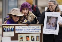 FILE - Ellen Isaacs, left, and Lee Nuss, center, both from Florida, hold each other and sing a song of remembrance for Randall M. Nuss, Lee's husband, during a protest with other advocates for opioid victims outside the U.S. Department of Justice, Dec. 3, 2021, in Washington. Families who lost loved ones to overdose are divided over OxyContin maker Purdue Pharma's plan to settle lawsuits over the toll of opioids with governments. It could provide billions to address an overdose epidemic and pay some victims. But it would also protect members of the Sackler family who own the company from future lawsuits. (AP Photo/Carolyn Kaster, File)