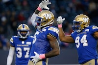 Winnipeg Blue Bombers' Willie Jefferson (5) and Jackson Jeffcoat (94) celebrate their sack of B.C. Lions quarterback Mike Reilly (not shown) during the first half of CFL action in Winnipeg Saturday, October 23, 2021. THE CANADIAN PRESS/John Woods