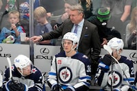 Winnipeg Jets head coach Rick Bowness, center top, gives instructions from the bench during the second period of an NHL hockey game against the Dallas Stars in Dallas, Thursday, April 11, 2024. (AP Photo/Tony Gutierrez)