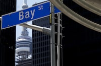 The Bay Street Financial District is shown next to the CN Tower in Toronto on Friday, Aug. 5, 2022. Canada's most prominent banks and insurers say they are sticking with the virtual or hybrid annual general meetings they adopted during the COVID-19 pandemic for another year. THE CANADIAN PRESS/Nathan Denette