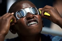 FILE - Blake Davis, 10, of Coral Springs, Fla., looks through solar glasses as he watches the eclipse, Monday, Aug. 21, 2017, at Nova Southeastern University in Davie, Fla. It’s only a year until a total solar eclipse sweeps across North America. On April 8, 2024, the moon will cast its shadow across a stretch of the U.S., Mexico and Canada, plunging millions of people into midday darkness. (AP Photo/Wilfredo Lee, File)