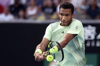 Felix Auger-Aliassime of Canada plays a backhand return to Daniil Medvedev of Russia during their third round match at the Australian Open tennis championships at Melbourne Park, Melbourne, Australia, Saturday, Jan. 20, 2024. (AP Photo/Asanka Brendon Ratnayake)