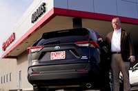 Scott Adams, owner of Adams Toyota, stands with a hybrid Toyota Rav4 at his dealership Tuesday, Dec. 12, 2023, in Lee's Summit, Mo. A typical hybrid costs somewhat more than its gasoline counterpart. A Toyota RAV4 hybrid with all-wheel-drive, for example, starts at $32,825, $1,600 more than a comparable gas version. (AP Photo/Charlie Riedel)
