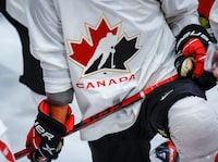 A Hockey Canada logo is shown on the jersey of a player with Canada’s National Junior Team during a training camp practice in Calgary on August 2, 2022.THE CANADIAN PRESS/Jeff McIntosh