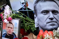 Flowers are seen placed around portraits of late Russian opposition leader Alexei Navalny, who died in a Russian Arctic prison, at a makeshift memorial in front of the former Russian consulate in Frankfurt am Main, western Germany, on February 23, 2024. (Photo by AFP) (Photo by -/AFP via Getty Images)