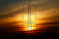 The sun sets behind an electricity pylon in Borehamwood, Britain, February 8, 2023.  REUTERS/Peter Cziborra