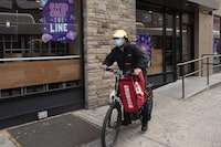 FILE - A delivery man bikes with a food bag from Grubhub on April 21, 2021, in New York. Uber Eats, DoorDash and Grubhub sued New York City on Thursday, July 6, 2023, to block its new minimum pay rules for food delivery workers. (AP Photo/Mark Lennihan, File)