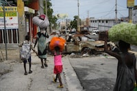 Residents walk past road blocks as they evacuate the Delmas 22 neighborhood to escape gang violence in Port-au-Prince, Haiti, Thursday, May 2, 2024. (AP Photo/Ramon Espinosa)