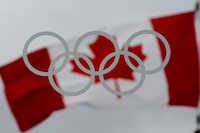 A Canadian flag flies behind Olympic rings on a window at the Main Press Centre for the Vancouver 2010 Winter Olympic Games in Vancouver, B.C., on Thursday January 21, 2010. The Games begin February 12. THE CANADIAN PRESS/Darryl Dyck