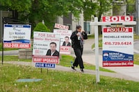 A person walks past multiple for-sale and sold real estate signs in Mississauga, Ont., on Wednesday, May 24, 2023. THE CANADIAN PRESS/Nathan Denette