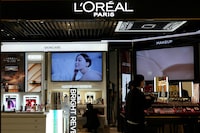 FILE PHOTO: Staff members work at a counter of cosmetics brand L’Oreal at a shopping mall in Beijing, China November 18, 2021. REUTERS/Tingshu Wang/File Photo