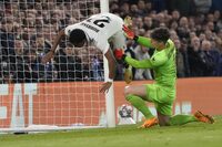 Real Madrid's Rodrygo, left, is fouled by Chelsea's goalkeeper Kepa Arrizabalaga after scoring his side's second goal during the Champions League quarterfinal second leg soccer match between Chelsea and Real Madrid at Stamford Bridge stadium in London, Tuesday, April 18, 2023. (AP Photo/Kirsty Wigglesworth)