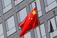 FILE PHOTO: A Chinese national flag flutters outside the China Securities Regulatory Commission (CSRC) building on the Financial Street in Beijing, China July 9, 2021. REUTERS/Tingshu Wang/File Photo