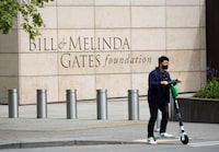 FILE PHOTO: A person passes by on a scooter in front of the Bill & Melinda Gates Foundation in Seattle, Washington, U.S. May 5, 2021.  REUTERS/Lindsey Wasson/File Photo